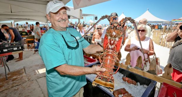 Man holding large lobster at Schooners Lobster Festival in Panama City Beach, Florida